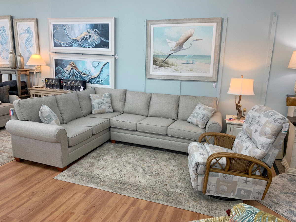 Two Anastasia Musick coastal prints styled above a sectional at Atlantic Fine Furniture